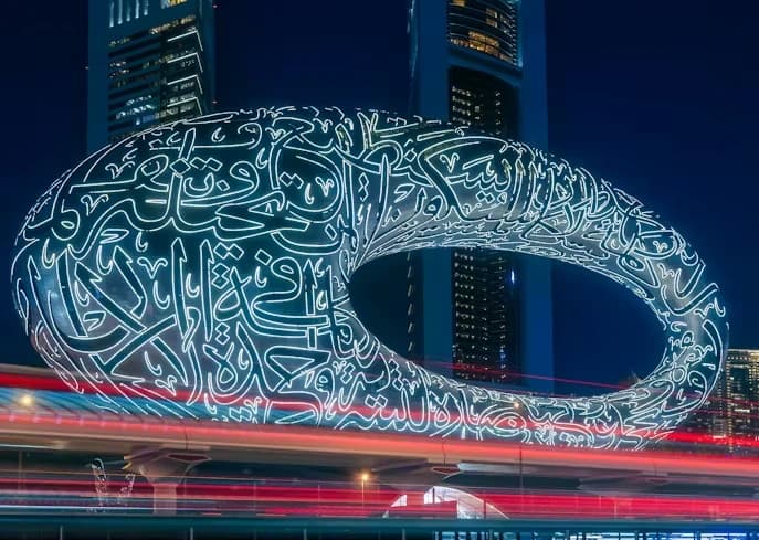 The Museum of the Future ring lit at night, Arabic calligraphy across its facade